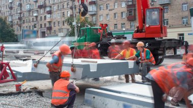 Vinç yol inşaat site timelapse, beton plaka yükleme. Kavganın ve üniforma ile sanayi işçileri. Tramvay parça kavşak üzerinde yeniden inşası