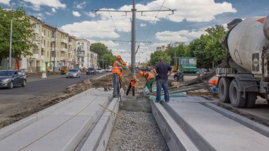 Beton yol bakım yapımı birçok işçi ve mikser makine timelapse ile çalışır. Tramvay parça yeniden inşası