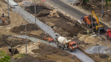 Beton yol yapım ile üniforma, ekskavatör ve mikser makine timelapse birçok işçi için çalışır. Tramvay yeniden inşası izler. Hava üstten görünüm