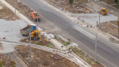 Zemin hareketli ve yol inşaat sitesinde bir damperli kamyon timelapse içine yükleme Endüstriyel Kamyon yükleyici tarak. Tramvay parça yeniden inşası, havadan görünümü