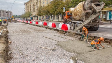 Beton yol yapım ile üniforma ve mikser makine timelapse birçok işçi için çalışır. Tramvay parça yeniden inşası