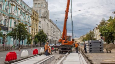 Vinç yol inşaat site timelapse, beton plaka yükleme. Kavganın ve üniforma ile sanayi işçileri. Sokak şehir tramvay yeniden inşası izler
