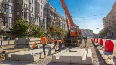 Vinç yol inşaat site timelapse, beton plaka yükleme. Kavganın ve üniforma ile sanayi işçileri. Sokak şehir tramvay yeniden inşası izler