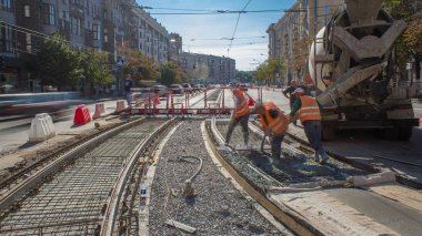 Beton yol yapım ile üniforma ve mikser makine timelapse birçok işçi için çalışır. Tramvay parça yeniden inşası