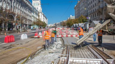 Beton yol yapım ile üniforma ve mikser makine timelapse birçok işçi için çalışır. Tramvay parça yeniden inşası