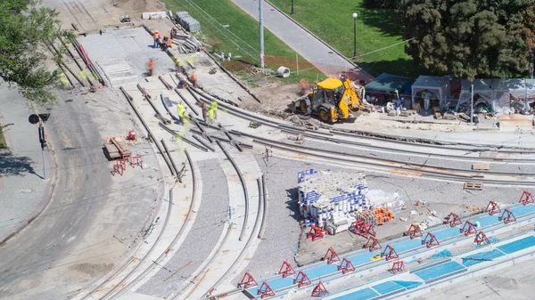 Repair works on the street timelapse. Laying of new tram rails on a city street. Installation of new modern railway rails for trams. Aerial top view. Reconstruction of tram tracks on intersection