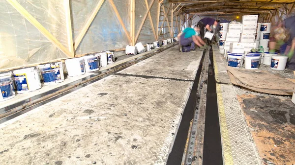 Tram rails at the final stage of their installation and integration into concrete plates on the road night timelapse. Filling by liquid resin for reduction of vibration and noice. The process of reconstruction of tram tracks