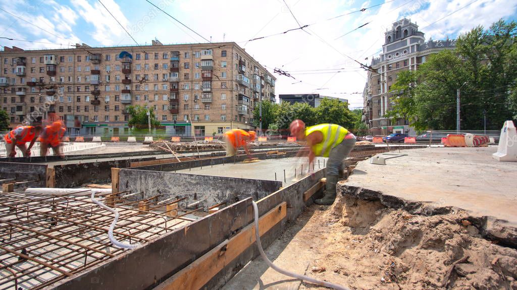 Concrete works for road construction with many workers and mixer timelapse hyperlapse. Reconstruction of tram tracks
