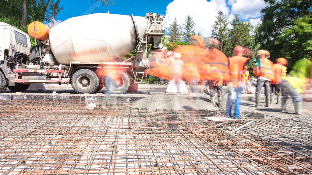 Concrete works for road construction with many workers and mixer timelapse hyperlapse. Pouring mortar to metal reinforcement. Reconstruction of tram tracks