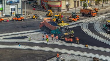 Asfalt Finişer, silindir ve kamyon yolda site timelapse asfaltlama sırasında onarın. Tramvay hava üstten görünüm yeniden yapılanma izler. Yol yapımı için makineler. İnşaat işçileri yol tamir.