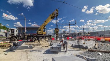 Vinç yol inşaat site timelapse, beton plaka yükleme. Kavganın ve üniforma ile sanayi işçileri. Sokak şehir tramvay yeniden inşası izler