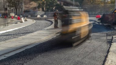 Asfalt Silindiri ve ekskavatör yolda site timelapse asfaltlama sırasında onarın. Tramvay görünümünü yeniden yapılanma izler. Yol yapımı için makineler. İnşaat işçileri yol tamir.