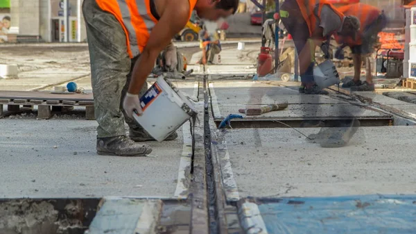 Tram rails at the final stage of their installation and integration into concrete plates on the road night timelapse. Filling by liquid resin for reduction of vibration and noice. The process of reconstruction of tram tracks