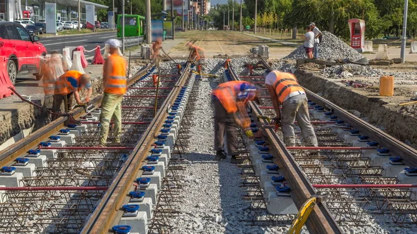 Onarım street timelapse üzerinde çalışır. Bir şehir sokak üzerinde yeni tramvay rayların döşenmesi. Yeni modern demiryolu rayları tramvaylar için montajı. Mandalları vagonlar üzerinde yükleme. Tramvay parça kavşak üzerinde yeniden inşası
