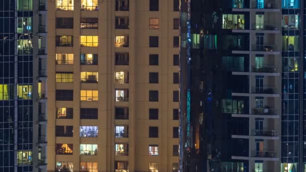 Des fenêtres éclatantes dans un immeuble résidentiel moderne à plusieurs étages en verre et en métal s'illuminent la nuit timelapse . — Video