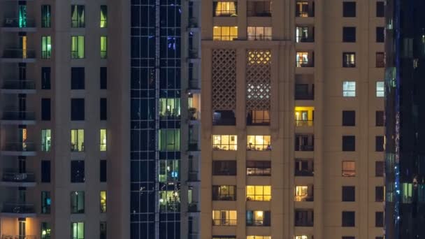 Finestre luminose in vetro moderno multipiano e metallo edificio residenziale si illuminano di notte timelapse . — Video Stock