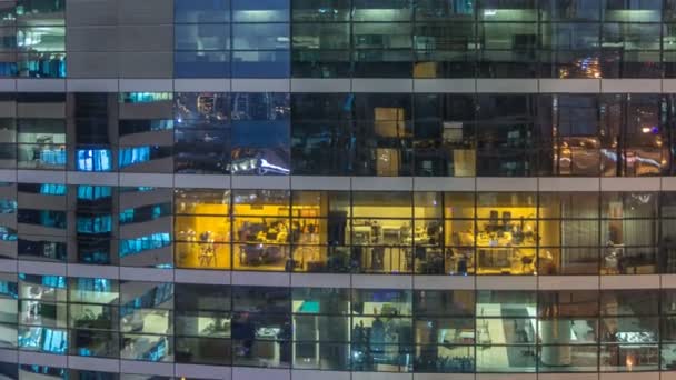 Ventanas brillantes en vidrio moderno de varios pisos y edificio de oficinas de metal se iluminan por la noche timelapse . — Vídeos de Stock