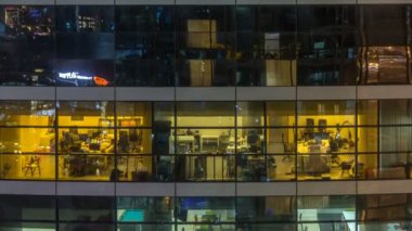Çok öykülü modern cam ve metal ofis ışık gece timelapse kadar bina içinde parlayan pencere eşiği.