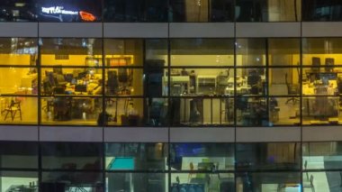Çok öykülü modern cam ve metal ofis ışık gece timelapse kadar bina içinde parlayan pencere eşiği.