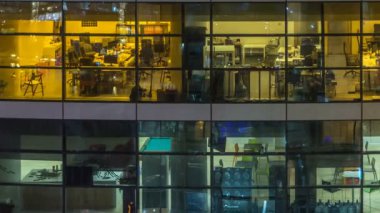 Çok öykülü modern cam ve metal ofis ışık gece timelapse kadar bina içinde parlayan pencere eşiği.