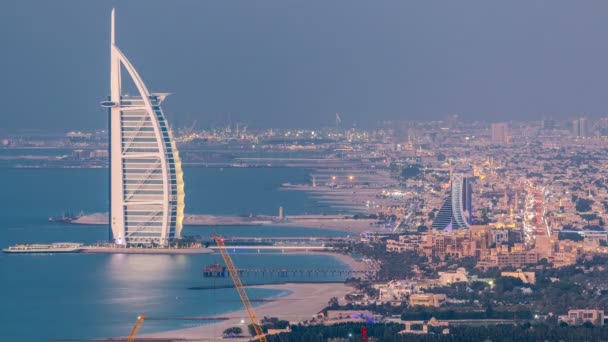 朱美拉海滩和迪拜的天际线与阿拉伯塔白天到晚上的过渡时间 Uae 的鸟图 船和交通在路 — 图库视频影像