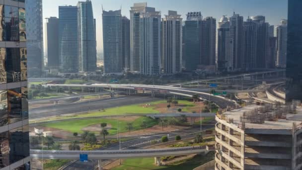 Aerial view to JLT and Dubai Marina with big highway intersection timelapse on sheikh zayed road and skyscrapers in the distance. — Stock Video