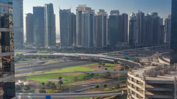 Luftaufnahme zum Jlt und Dubai-Yachthafen mit großem Autobahnkreuz im Zeitraffer auf der Scheich-Zayed-Straße und Wolkenkratzern in der Ferne. — Stockvideo
