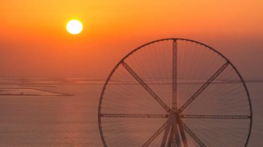 Bluewaters Adası'nda dönme dolap ile günbatımı hava timelapse
