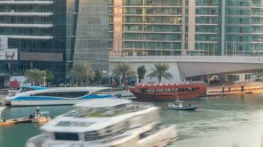 Yat ve tekne shoping mall kalıyor ve Dubai Marina bölge timelapse bir köprü altında geçen turist.