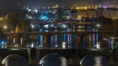 Hava gece görünümü Vltava Nehri ve trafik timelapse, Prag ile ışıklandırılmış köprüleri. Tekneler amd gemi su üzerinde yüzer. Hanavsky Pavilion üstten görünüm