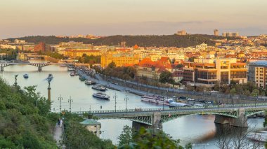Aerial sunset view of the Vltava River and bridges with traffic evening timelapse, Prague. Boats amd ship floating on water. Warm orange light. Top view from Hanavsky pavilion clipart