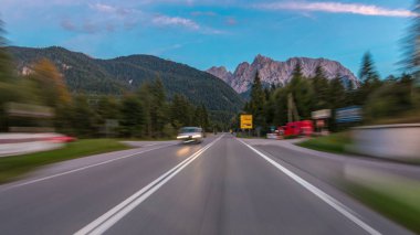 Avusturya, bir güzel sonbahar günü timelapse hyperlapse drivelapse Alpler'de asfalt yolda sürücü. Orman ve dağlar akşam