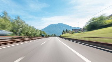 Dağlar ve çayırlar İtalya timelapse hyperlapse drivelapse içinde bir otoyolda sürüş. Elektrik direkleri, güzel manzara ve mavi gökyüzü ile beyaz bulutlar. Yüksek hız