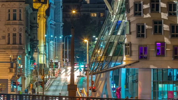 Traffic on the street near Dancing house in Prague timelapse, Czech republic. Modern architecture. Night view from Jiraskuv Bridge