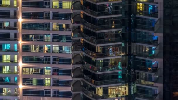 Finestre luminose in vetro moderno multipiano e metallo edificio residenziale si illuminano di notte timelapse . — Video Stock