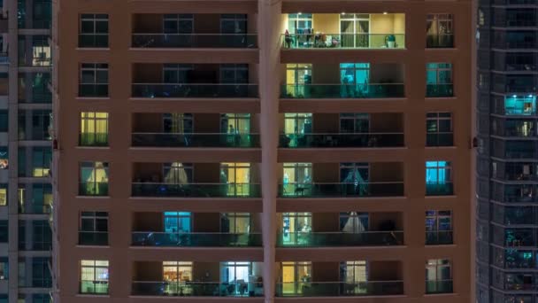 Λαμπερό windows σε πολυώροφο σύγχρονο γυαλί κατοικιών κτίριο φως στο Χρονοεγγραφή νύχτα. — Αρχείο Βίντεο