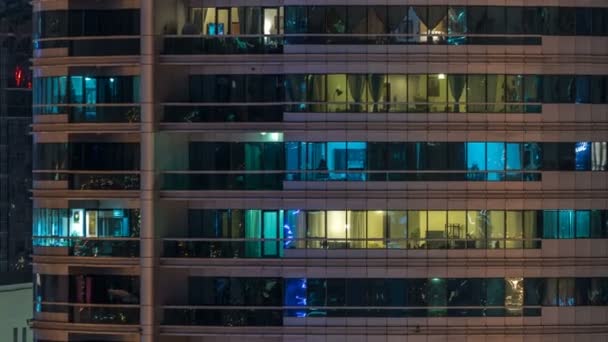 Світлові вікна в багатоповерховому сучасному склі житловий будинок освітлюється в нічний час . — стокове відео