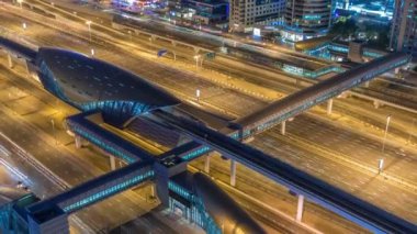 Futuristik binada Dubai metro ve tramvay istasyonu ve lüks gökdelenler arkasında gece timelapse