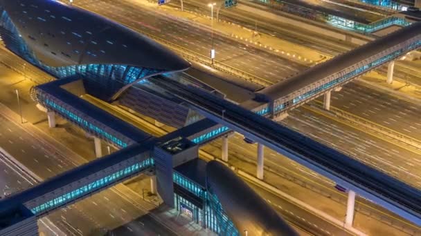 Futuristisk byggnad i Dubai metro och spårvagn station och lyxiga skyskrapor bakom natt timelapse — Stockvideo