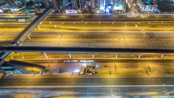 谢赫扎耶德路交通在迪拜码头和朱美拉湖塔区夜间经过时间 Jlt 的空中顶部的看法与停车场 — 图库视频影像