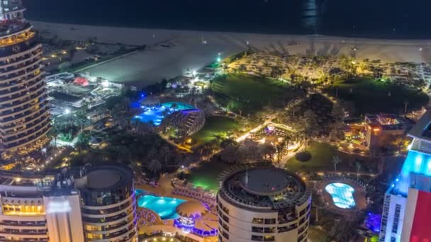 近代的な高層ビルとドバイ、アラブ首長国連邦のジュメイラ ビーチ レジデンス Jbr 夜のタイムラプスでビーチの空撮 — ストック動画