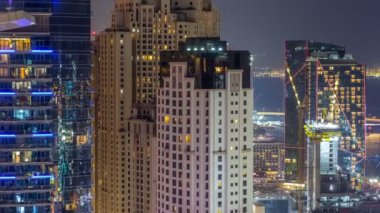 Modern gökdelenler ve Jumeirah Beach Residence Jbr gece timelapse Dubai, BAE kumsalda havadan görünümü
