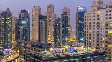 Dubai Yat Limanı hava görünümünü gece geçiş timelapse için bir noktadan günden güneş battıktan sonra. Modern gökdelenler ve konut kuleleri de akşam aydınlatılmış. Yolda trafik
