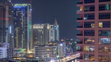 Dubai Marina havadan görünümden bir noktadan gece timelapse. Waterfront adlı mesire üzerinde yürüyen insanlar. Modern gökdelenler ve konut kuleleri parlayan pencerelerle aydınlatılmış