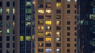 Çok öykülü modern cam ve metal kadar ışık gece timelapse bina konut içinde parlayan pencere eşiği. Daireler insanlar. Geceleri aydınlatılan evler. Dubai Yat Limanı ve Jbr, Birleşik Arap Emirlikleri