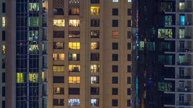 Çok öykülü modern cam ve metal kadar ışık gece timelapse bina konut içinde parlayan pencere eşiği. Daireler insanlar. Geceleri aydınlatılan evler. Dubai Yat Limanı ve Jbr, Birleşik Arap Emirlikleri