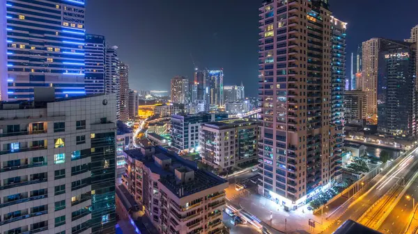 迪拜码头的鸟图从有利的角度 夜间经过 现代化的摩天大楼和住宅塔楼被发光的窗户照亮 路上的交通 — 图库照片