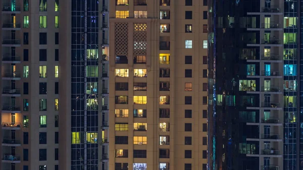 Çok öykülü modern cam ve metal kadar ışık gece timelapse bina konut içinde parlayan pencere eşiği. Daireler insanlar. Geceleri aydınlatılan evler. Dubai Yat Limanı ve Jbr, Birleşik Arap Emirlikleri. Yakınlaştır