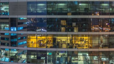 Çok öykülü modern cam ve metal ofis kadar ışık gece timelapse Bina içinde parlayan pencere eşiği. İşçiler bir kutu içinde. Geceleri aydınlatılan Ofis Binası.