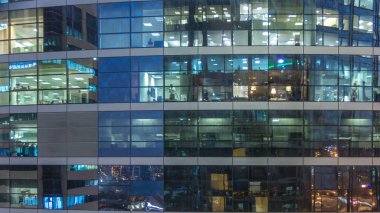 Çok öykülü modern cam ve metal ofis kadar ışık gece timelapse Bina içinde parlayan pencere eşiği. İşçiler bir kutu içinde. Geceleri aydınlatılan Ofis Binası.